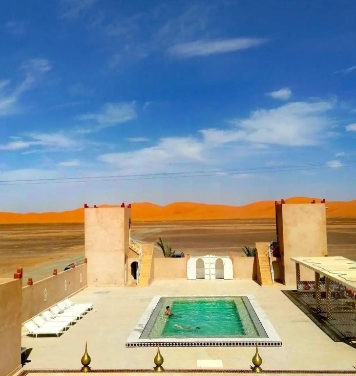 Morocco desert hotel luxury camp inside Erg Chebbi dunes at sunset Merzouga Sahara